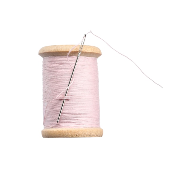 Розовая швейная нить с иглой, изолированной на белом