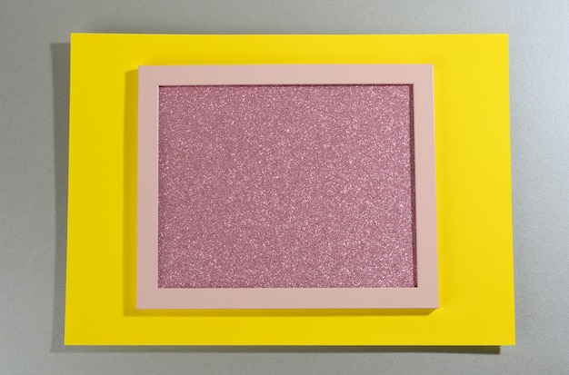 Pink shiny rectangular frame on gray-yellow surface with shadow. Template