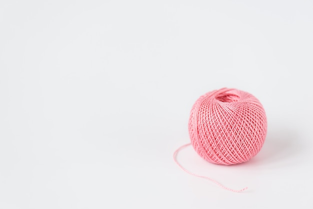 Pink skein of thread for knitting on a white background