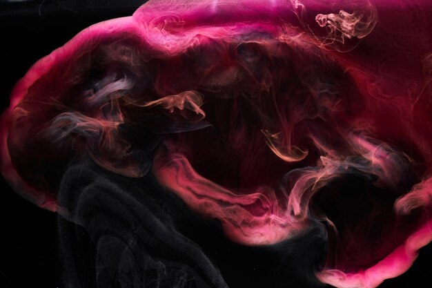 Pink smoke on black ink background, colorful fog, abstract swirling touch ocean sea, acrylic paint pigment underwater