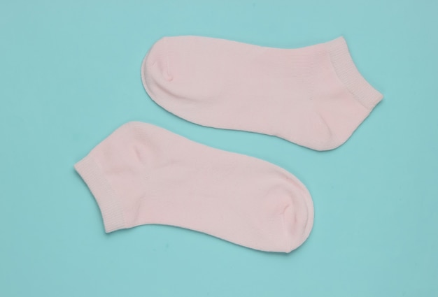 Pink socks on blue background Minimalism fashion concept