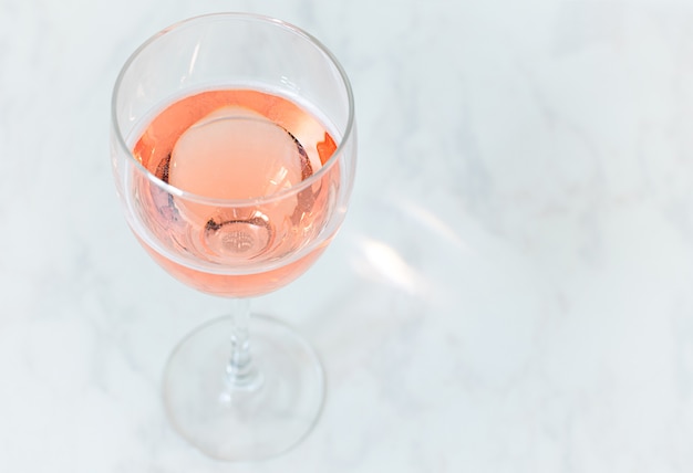 Фото Розовое игристое вино в стакане на столе с копией пространства.