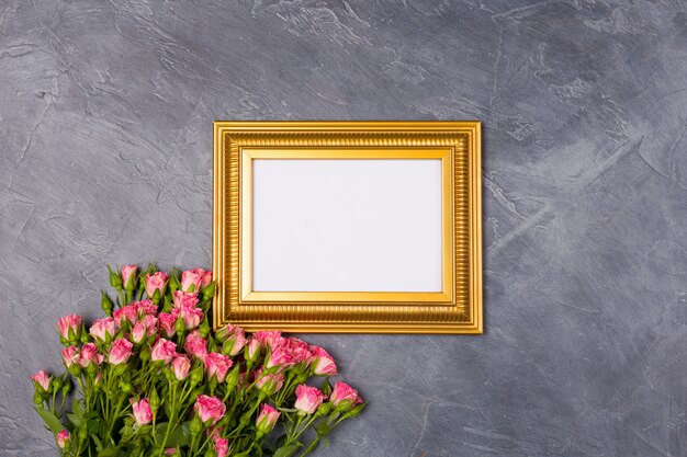 pink spray roses and blank paper on grey background. top view copy space. birthday woman's day mother's concept. 