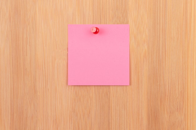 Pink sticky note pinned to the wooden message board