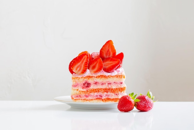 Foto torta di fragole rosa sulla tavola bianca