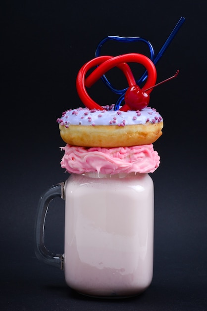 Pink strawberry freakshake with marshmallow and sweets