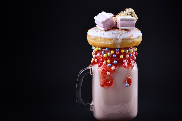 Pink strawberry shake with marshmallow and sweets