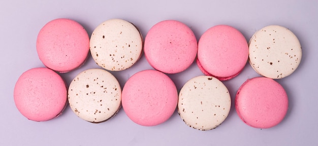 Photo pink strawberry and white caramel and salt macarons french delicate dessert pink and white pastel macarons long top view