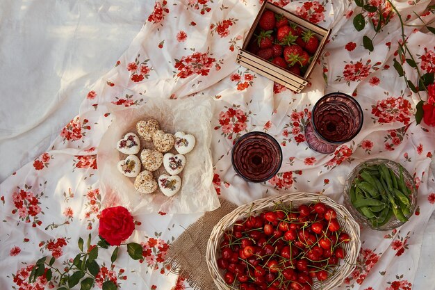 Pink summer picnic - tablecloth box of marshmallows strawberries cherry peas and glasses of wine