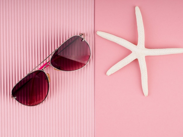 Photo pink sunglasses on pink background, holiday concept, postcard, summer and travel.