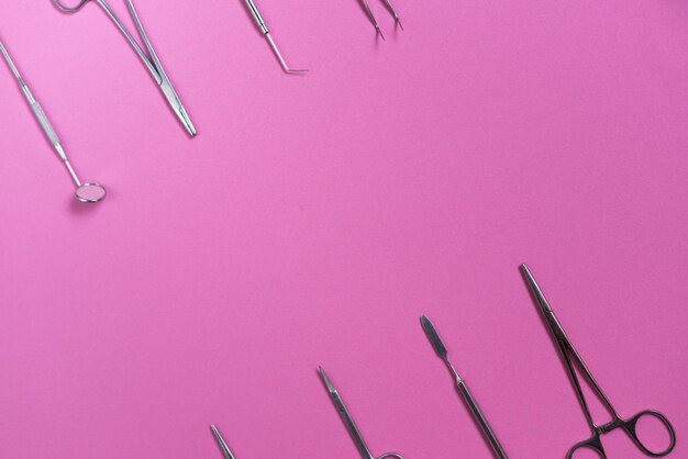 On the pink surface are medical dental instruments