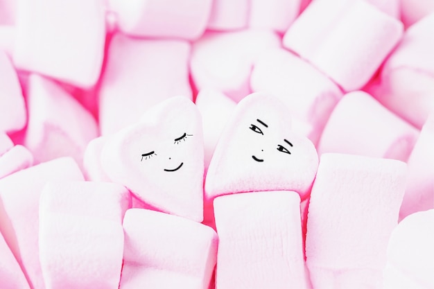 Photo pink sweet marshmallow hearts with funny smiling face