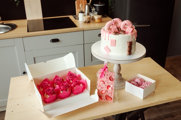 Pink sweets such as birthday cake marshmallows cupcakes and chocolate on the kitchen table