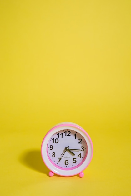 Pink table clock isolated wih copy space