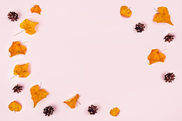 Photo pink table with orange leaves and pine cones