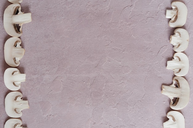 Pink textured surface and a frame of the mushroom slices