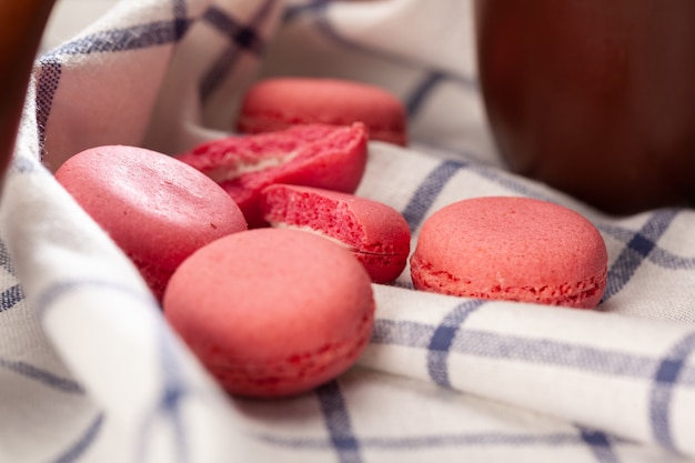 Розовые крошечные печенья макарон на скатерть крупным планом