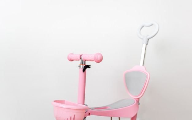 Pink toddler scooter for a baby. Summertime activity for kids.