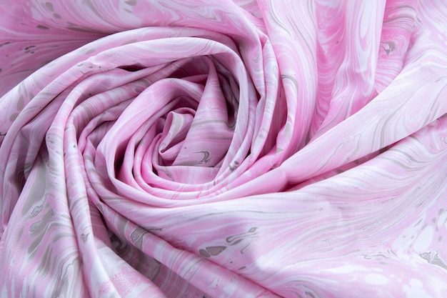 ベースカラーのシルクのピンクの上面図、ピンクの大理石のパターンのシルクの生地、波状、らせん状、折り目、渦巻き、背景、布の背景、テキストのコピースペースがあります