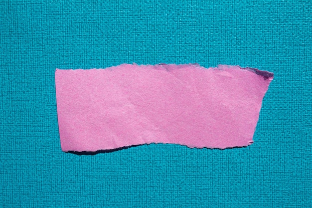 Pink torn piece of paper on a blue background