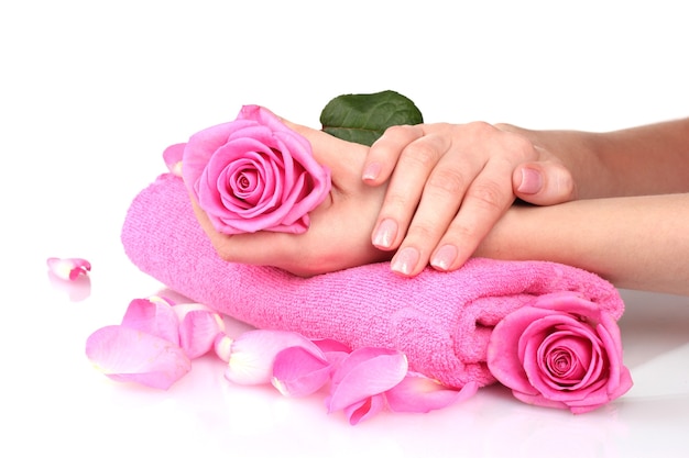 Pink towel with roses and hands on white table