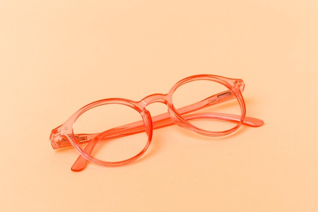 Pink transparent glasses isolated on beige background