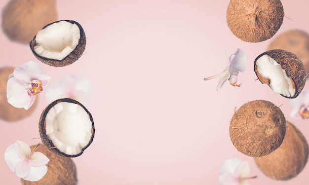 Pink tropical summer background with falling coconuts