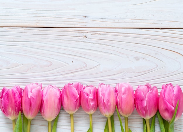 Foto fiore rosa del tulipano su fondo di legno