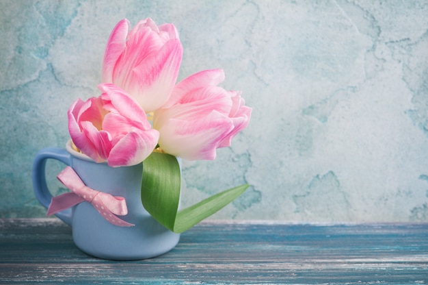 Pink tulip flowers in blue mug