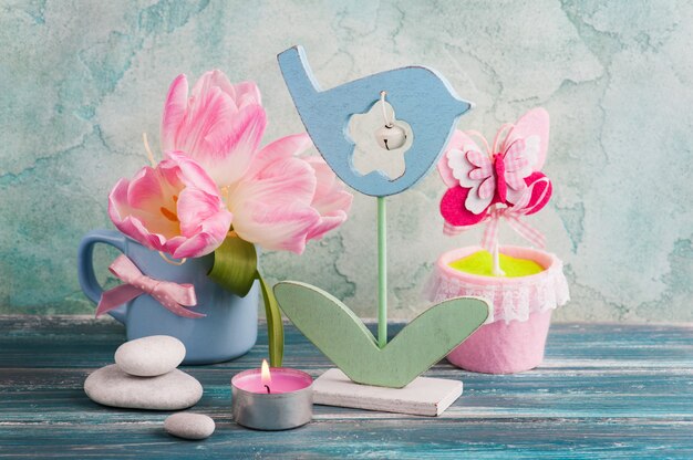 Pink tulip flowers, lit candle