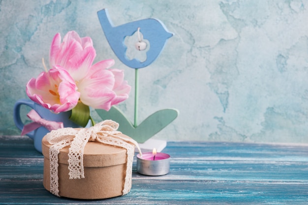 Pink tulip flowers, lit candle