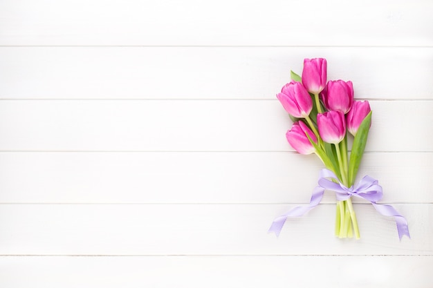 Pink tulip on the white surface. 