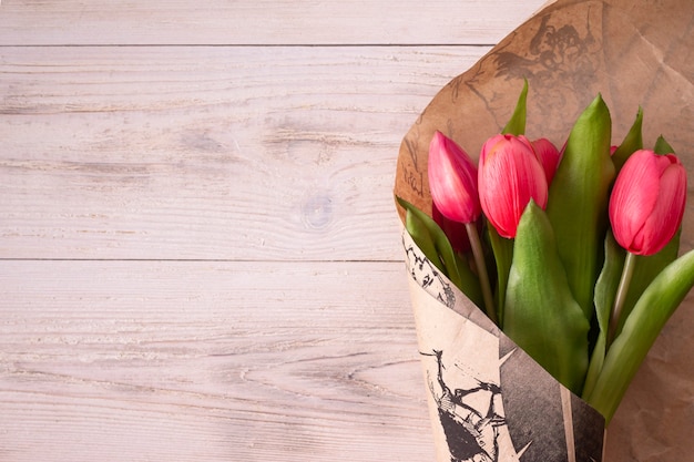 Pink tulips are wrapped in kraft paper