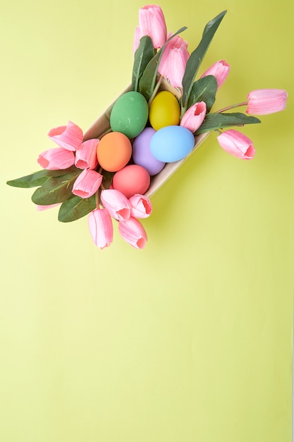 Pink tulips in box and Egg Easter on yellow