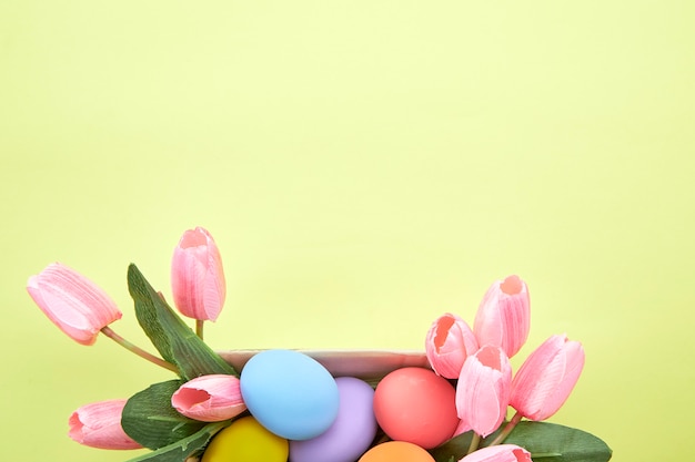 Pink tulips in box and Egg Easter on yellow