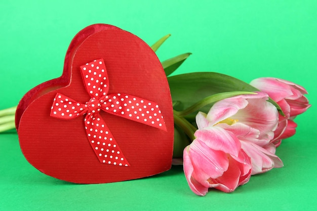 Pink tulips and gift box, on color background