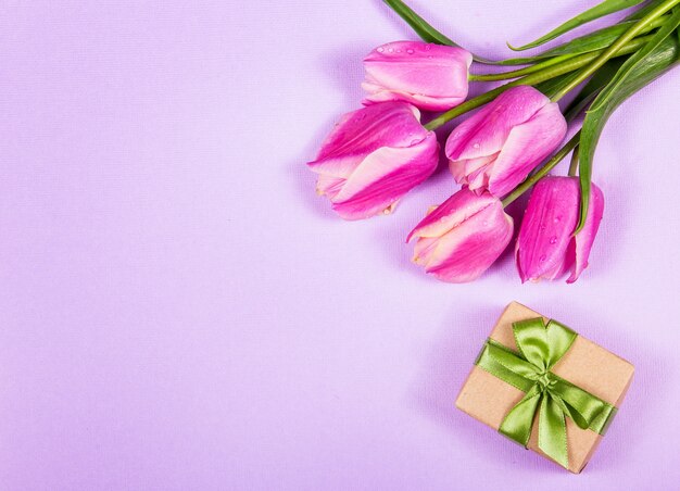 Pink tulips and gift box on pink background