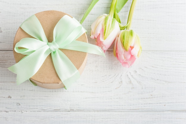 Pink tulips and gift box with green ribbon