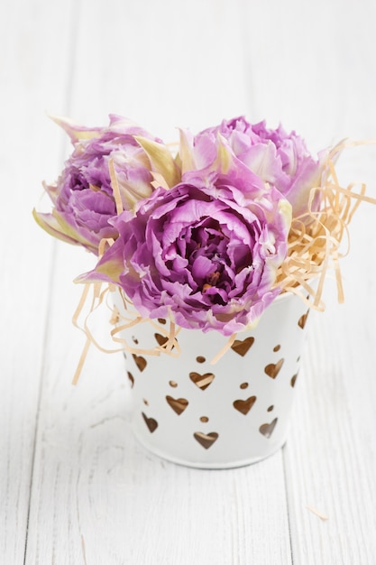 Pink tulips in tin bucket with heart-shaped holes