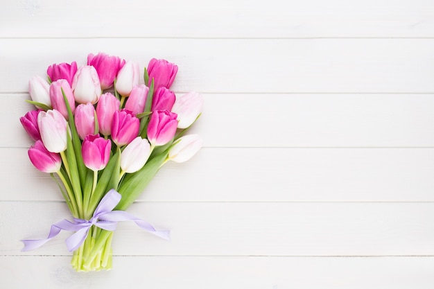 Pink tulips on white wooden table