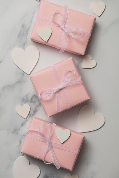 Pink valentine gift with white hearts on a marble background