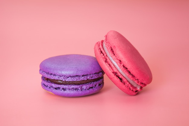 Pink and Violet macaroons on a fashionable coral background close-up