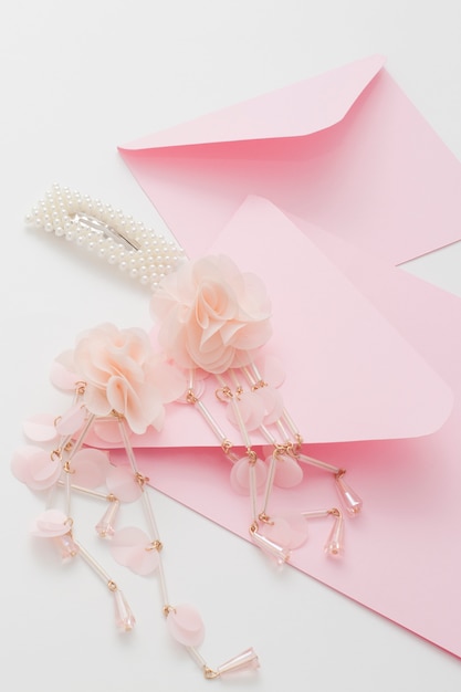 Photo pink wedding invitations are decorated with the bride's hair clip and earrings. concept preparation for the wedding.