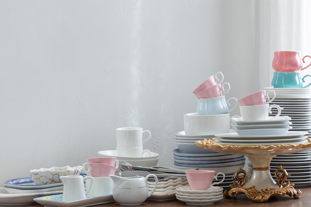 Pink white abd blue cutlery on a wooden table against a white wall