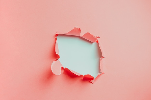 pink and white background of hole in card stock with copy space