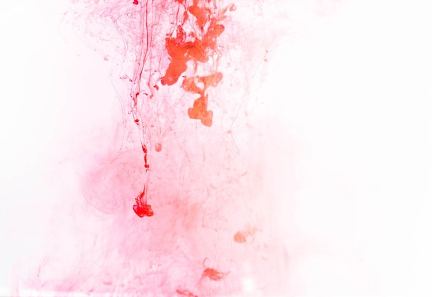 A pink and white background with a red stain and a drop of blood.