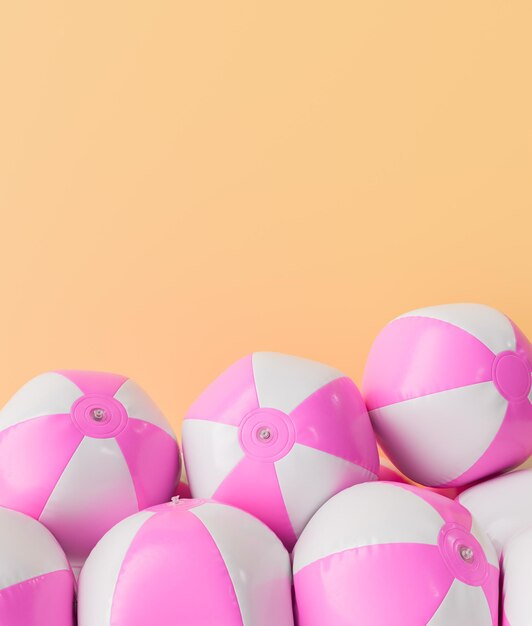 Photo pink and white beach balls piled against a peach background