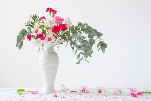 Pink and white flowers in vase on white background