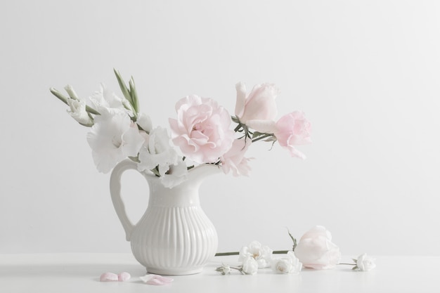 Pink and white flowers in vase on white background