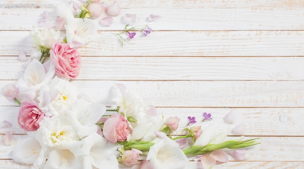 白い木製の背景にピンクと白の花